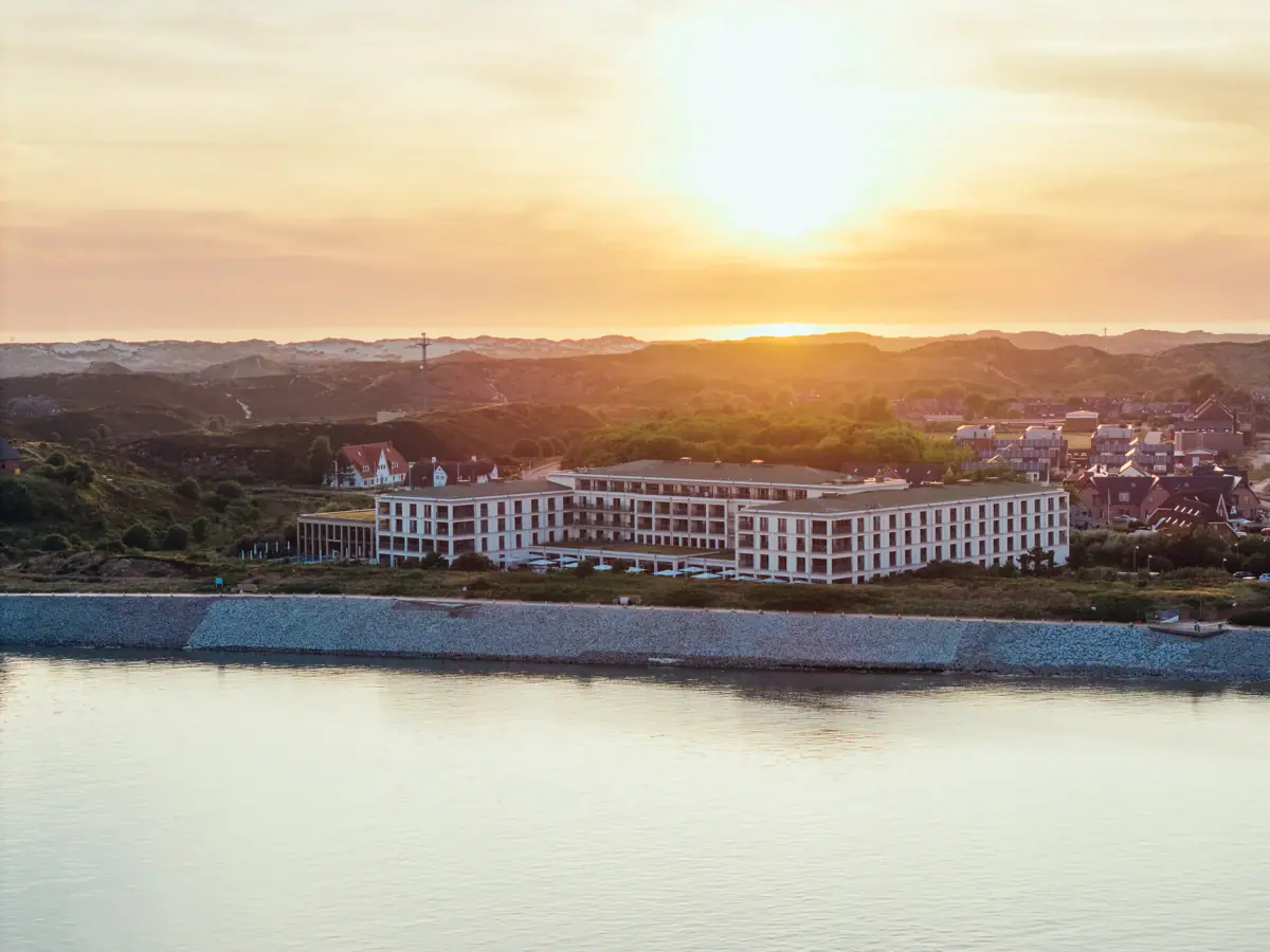 A building next to a body of water outdoors at dawn.