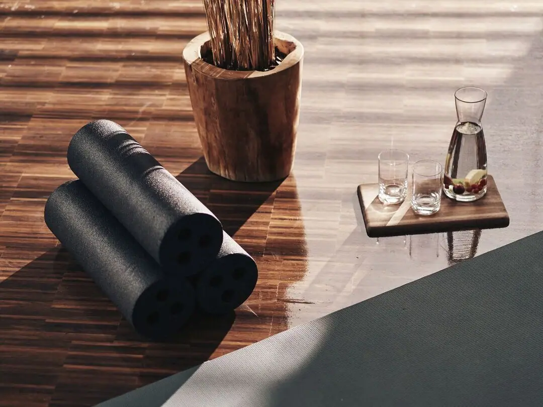 Yogamatten und Gläser auf einem Holzboden