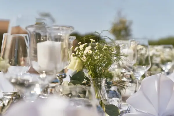 Elegantly laid table with flower arrangements and glasses.