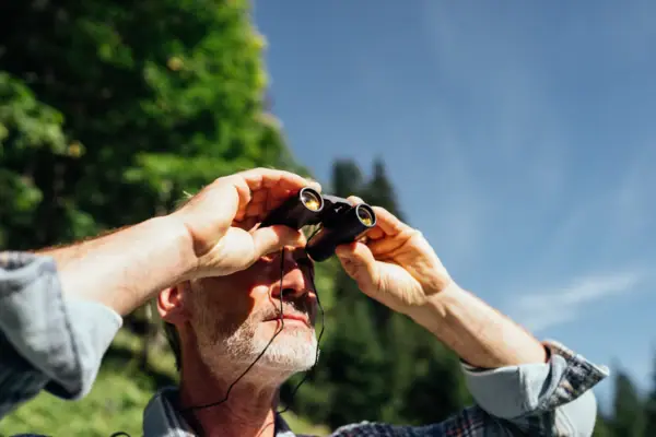 Man looks into binoculars A man looks through binoculars.
