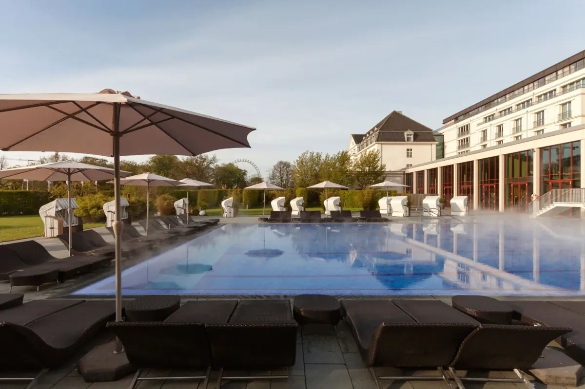 The outdoor pool at A-ROSA Travemünde, complete with sun loungers and parasols.