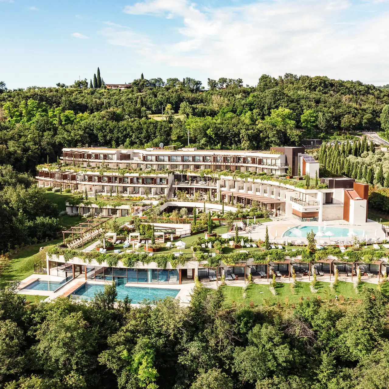 Ein Gebäude mit einem Pool, umgeben von Bäumen.