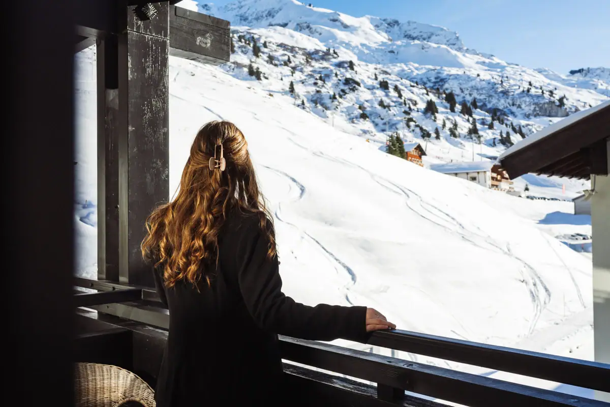 Eine Frau blickt auf einen schneebedeckten Berg.