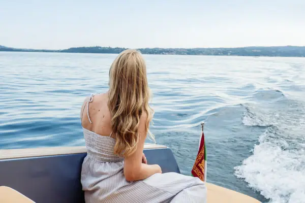 Boat trip to Isola del Garda A woman is sitting in a boat.