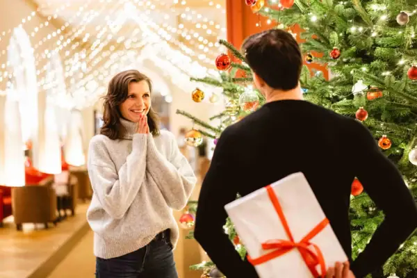 A man and woman standing next to a decorated Christmas tree.