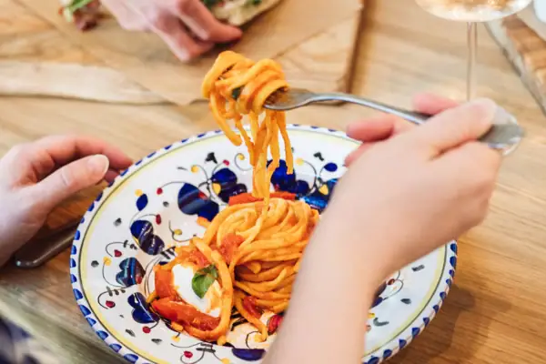 Eine Person isst ein Gericht auf einem Teller.