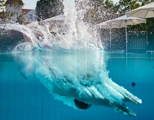 A person dives into a swimming pool.