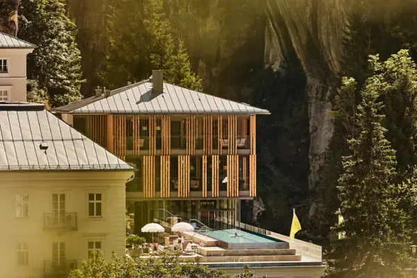 Building with pool in the centre, surrounded by trees and plants.