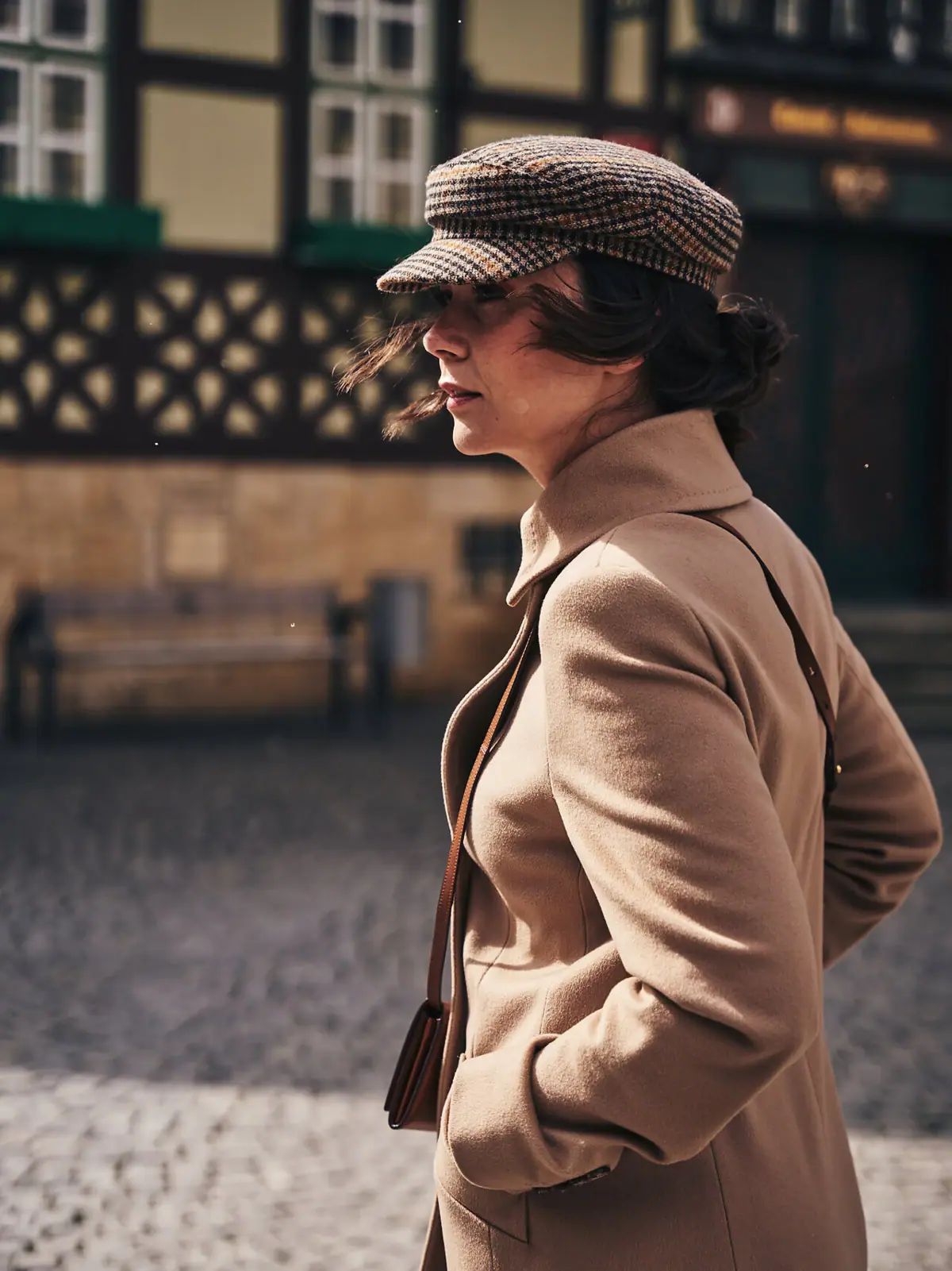 A woman in a brown coat and hat is strolling through Wernigerode in the Harz Mountains.