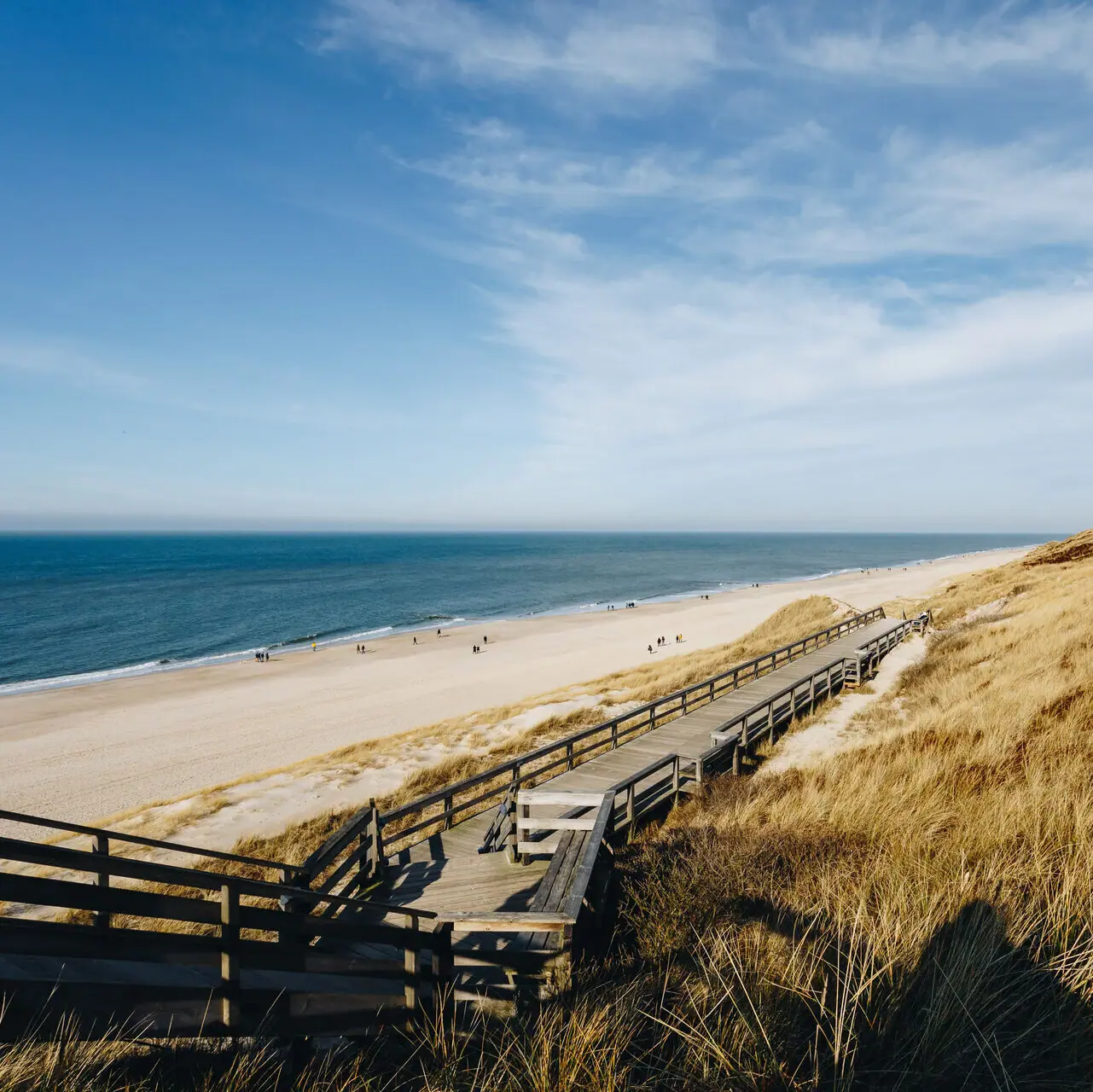 A wooden jetty leads to a beach on Sylt.