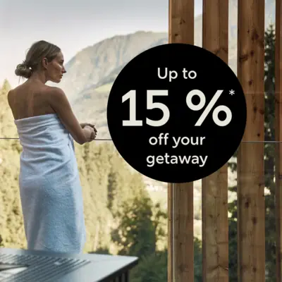 A woman wrapped in a towel outdoors.